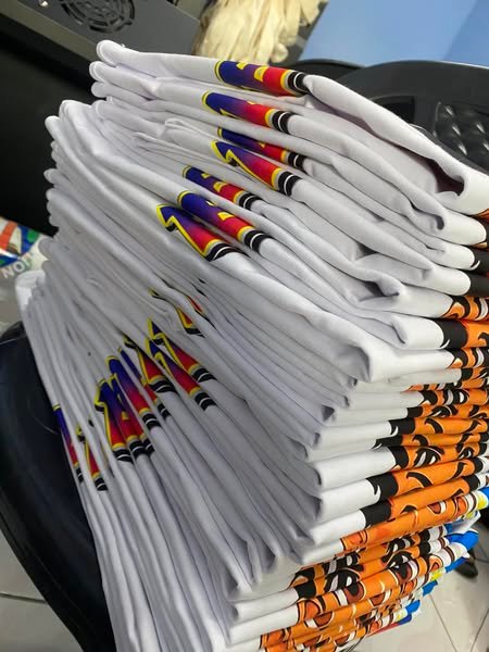 Prendas blancas personalizadas, apiladas y listas para entregar